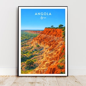 May include: Framed print of Angola, Africa, depicting a striking canyon with layered orange and tan rock formations. The image is set against a clear blue sky, with the text "ANGOLA Africa" displayed at the top of the print.