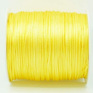 May include: A spool of bright yellow waxed cord.