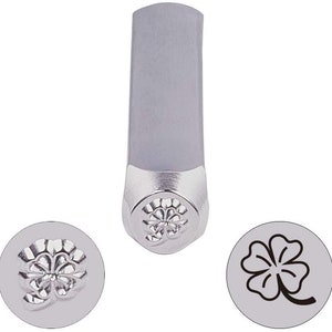 May include: A metal stamp with a four-leaf clover design. The stamp is used to create impressions in metal.
