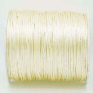 May include: A spool of off-white waxed cord, perfect for jewelry making, macrame, or crafts.