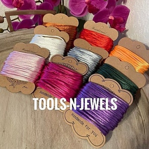 May include: Assortment of colorful spools of thread on brown cardstock with the text "TOOLS-N-JEWELS Handmade for you".