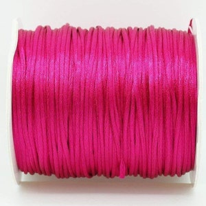 May include: A spool of bright pink waxed cord, perfect for jewelry making, macrame, or crafts.