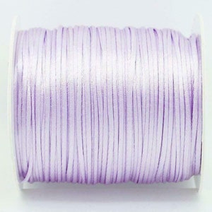 May include: A spool of light purple satin cord.