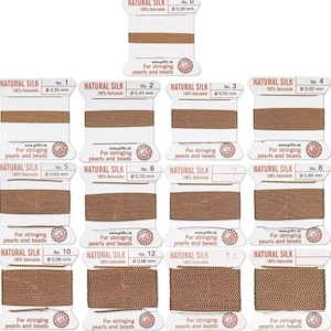 May include: Assortment of 14 spools of natural silk thread for stringing pearls and beads. The spools are labeled with numbers 0 through 14 and their corresponding diameters in millimeters.