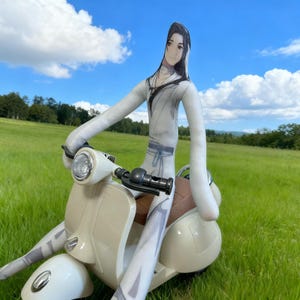 May include: A cream-colored scooter with a brown seat and a doll-like figure riding it. The figure is dressed in a white outfit with long arms and legs. The background is a green field and a blue sky with clouds.