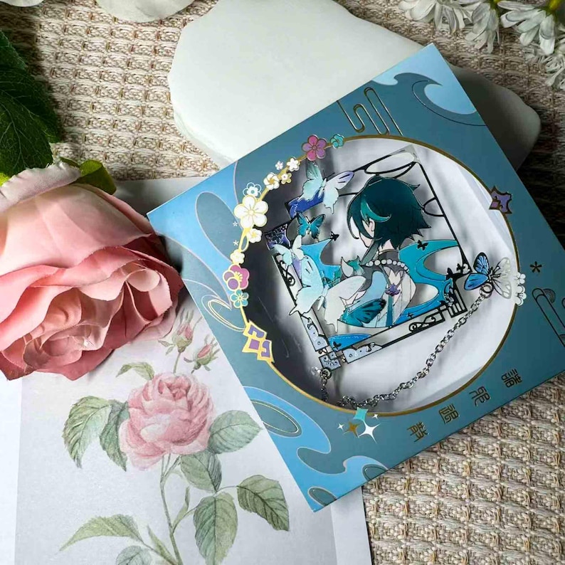 May include: A blue and white decorative card featuring a character illustration with butterflies and floral accents. The card has a circular design with a silver chain and star charm. The overall theme is anime or manga.