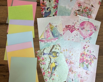 May include: A collection of colorful stationery, including blank cards and envelopes. The cards feature various designs, such as birds, hot air balloons, sailboats, and butterflies, with floral and watercolor backgrounds. The envelopes are in pastel shades.