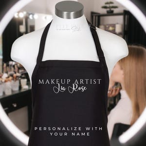 May include: Black makeup artist apron with white text that reads "Makeup Artist Jia Rose" and "Personalize with your name".