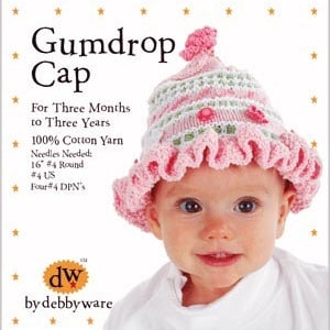Puede incluir: Un bebé con un "Gumdrop Cap" de ganchillo rosa y blanco. El sombrero tiene un borde con volantes y una parte superior decorativa. El texto en el sombrero dice "Gumdrop Cap" y "For Three Months to Three Years."