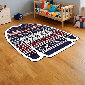 May include: A blue and white patterned rug shaped like a sweater with red and white accents. The rug is on a wooden floor.