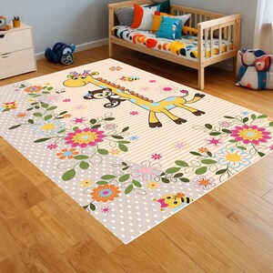 Può includere: Un tappeto rosa chiaro e beige con un motivo a righe e un design di cartoni animati con una giraffa e una scimmia. Il tappeto presenta una varietà di fiori e api colorati.