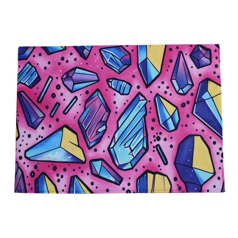 Peut inclure: Tissu rose avec un motif r&eacute;p&eacute;titif de cristaux abstraits color&eacute;s. Les cristaux sont dans des tons de bleu, violet et jaune.