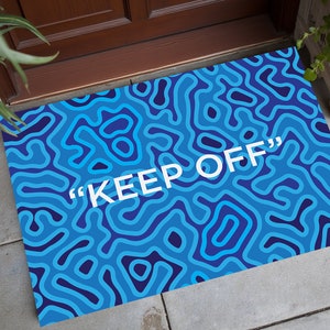 Könnte beinhalten: Ein Set aus drei Keramikbechern mit gesprenkelter, matter Oberfläche. Die Becher sind in den Farbtönen Creme, Hellgrau und Dunkelgrau gehalten. Jeder Becher hat ein schlichtes, minimalistisches Design und einen abgerundeten Henkel.