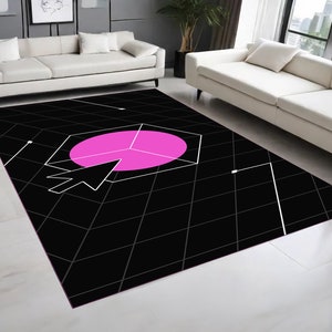 May include: Black and white geometric rug with a pink circle in the centre. The circle has a white arrow pointing to the right.