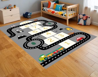 May include: A grey and black play mat with a hopscotch game and a road course. The hopscotch squares are yellow with black numbers 1-10. The road course has black lines and white dashes. There are small images of animals and vehicles on the mat.