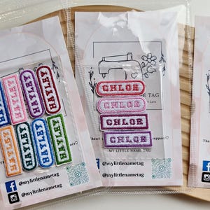 Peut inclure: Deux emballages en plastique transparent contenant des écussons rectangulaires brodés. Un paquet contient huit écussons avec le nom HAYLEY en différentes couleurs. L'autre contient quatre écussons avec le nom CHLOE. Chaque carte porte un logo de machine à coudre.