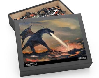 Op de afbeelding: Een puzzel van 500 stukjes met een zwarte draak die vuur spuit tegen een vurige oranje en gele achtergrond. De puzzeldoos is zwart met een wit label waarop staat "16x20 Puzzle 500 pcs Ages 9+"