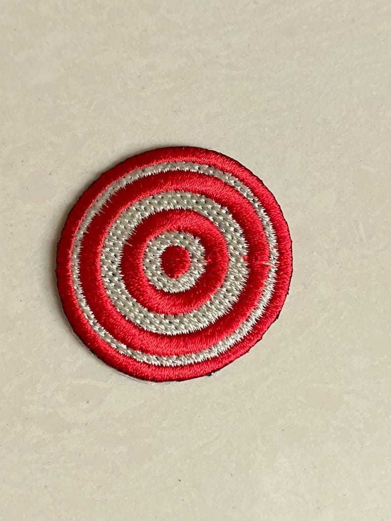 May include: Red and white embroidered circle patch with concentric circles.