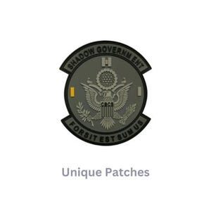 May include: A gray and black embroidered patch with the text "Shadow Government" and "Fortis Est Sumus Us" around a stylized eagle with the text "CRCS" on its chest.