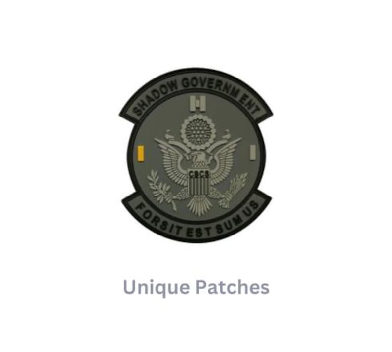 May include: A gray and black embroidered patch with the text "Shadow Government" and "Fortis Est Sumus Us" around a stylized eagle with the text "CRCS" on its chest.