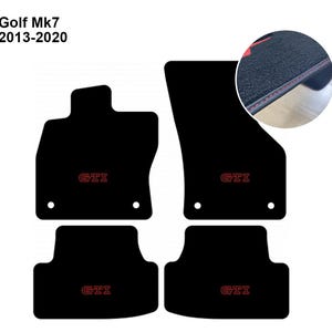 Puede incluir: Un juego de cuatro alfombrillas negras para coche Golf Mk7 2013-2020. Cada alfombrilla presenta un logotipo GTI bordado en rojo y un recorte circular para el montaje. Un recuadro circular muestra la superficie de moqueta negra con bordes cosidos en rojo.