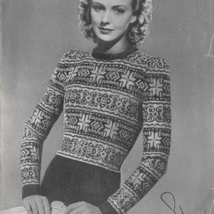 May include: Black and white vintage sweater with a geometric pattern. The long-sleeved sweater has a crew neck and is fitted. The model is wearing the sweater and is holding a white object. The image is in black and white.