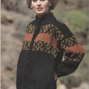 May include: A black knitted cardigan with a geometric pattern in brown, red and green. The cardigan has a high neck and a button fastening.