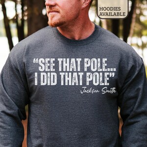 May include: Dark gray sweatshirt with the text "SEE THAT POLE... I DID THAT POLE" in white, with "Jackson Smith" in a script font. The sweatshirt is a crew neck style.