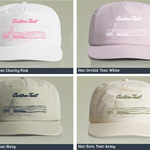 May include: Four different colored baseball caps with a surfboard graphic and the text "Custom Text" on the front. The hats are white, orchid, taupe, and ecru.