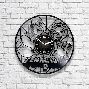 May include: Black and white vinyl record clock featuring a cartoon image of two people with the text "Tenacious D" below.