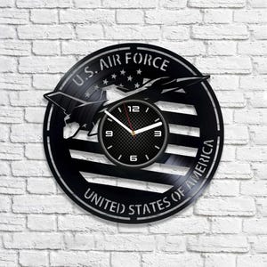 May include: Black vinyl record clock featuring a silhouette of a fighter jet and the text "U.S. AIR FORCE UNITED STATES OF AMERICA".