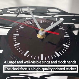 May include: A black and white vinyl record clock featuring a silhouette of a car. The clock face has large, easy-to-read numbers and hands. The clock face is a high-quality printed sticker. "Large and well-visible sings and clock hands. The clock face is a high-quality printed sticker."