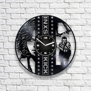 May include: Black vinyl record clock featuring a silhouette of a person skateboarding and the text "INXS KICK" with stars around the text.