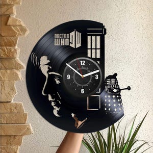 Puede incluir: Reloj de vinilo negro con una silueta del Doctor de Doctor Who, la TARDIS y un Dalek. La esfera del reloj es blanca con números y manecillas negros.