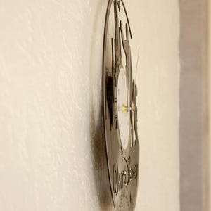May include: A black vinyl record clock featuring a silhouette of Cinderella's castle and the text "Walt Disney" with a white clock face.
