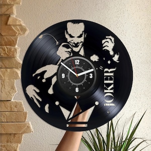 Può includere: Orologio in vinile nero con una silhouette del Joker di Batman. Il quadrante dell'orologio è bianco con numeri e lancette neri. Il disco è etichettato "Joker" in lettere bianche.