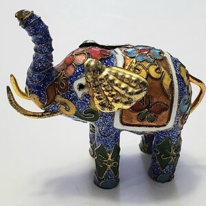 May include: A white ceramic mug with a black handle and the text "But First, Coffee" in a black, bold font. The mug is on a white surface.