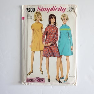 Peut inclure: Patron de couture Simplicity vintage 7200 pour robes mini-longueur. La couverture présente des illustrations de trois robes : jaune, rouge à motifs floraux et turquoise. Le texte comprend "Simplicity", "Taille 14" et "Simple-to-Sew".