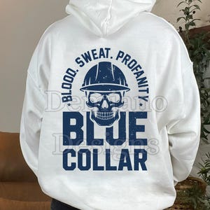 May include: White hoodie with a blue graphic featuring a skull wearing a hard hat, with the words "BLOOD. SWEAT. PROFANITY." above and "BLUE COLLAR" below. The hoodie is a casual garment, suitable for everyday wear.