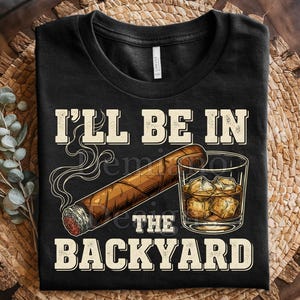 May include: Black t-shirt with the text "I'll Be In The Backyard" above a graphic of a lit cigar and a glass of whiskey with ice. The design is in a vintage style.