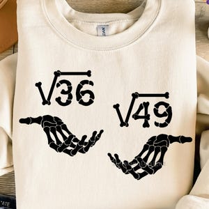 May include: Cream-colored sweatshirt with black graphic of square root symbols and skeleton hands. The text "√36" and "√49" are above the hands. The bottom of the image has the text "300DPI / SVG+PNG / DEGITAL FILE".