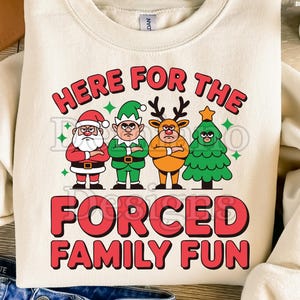 May include: Cream-colored sweatshirt with the text "HERE FOR THE FORCED FAMILY FUN" in red and white. The graphic features Santa, an elf, a reindeer, and a Christmas tree, all with grumpy expressions. A fun holiday design.