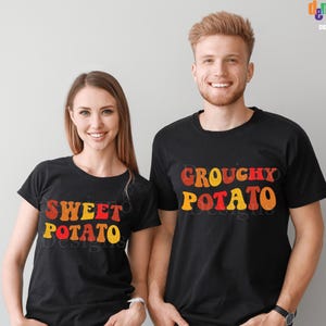 以下が含まれることがあります： お揃いの黒いTシャツを着た2人。1つのシャツには、赤、オレンジ、黄色の文字で「Sweet Potato」と書かれています。もう1つのシャツには、同様の色で「Grouchy Potato」と書かれています。これらのシャツはデジタルファイルの一部です。