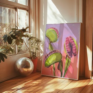 May include: A framed rectangular wall art print featuring a stylized illustration of three Venus flytrap plants with vibrant green traps and pinkish-purple interiors, set against a soft lavender and pink gradient background with visible brushstrokes.