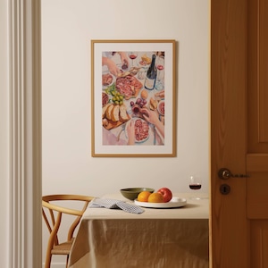 May include: A framed print depicts a table laden with food and drink. The scene includes a bottle of wine, glasses, bread, grapes, and various meats. The artwork is in a warm color palette, with a focus on the arrangement of the meal.