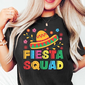 May include: Black t-shirt with a colorful graphic of a sombrero and the text "Fiesta Squad".