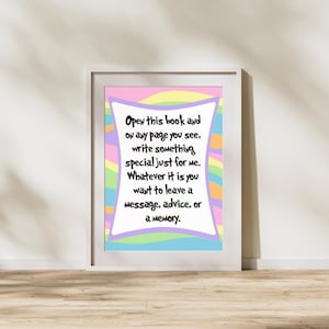 Op de afbeelding: Een ingelijste print met een witte rand. Het kunstwerk heeft een pastelkleurige regenboogachtergrond met een wit tekstvak met de tekst "Open this book and on any page you see, write something special just for me."