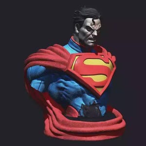 Puede incluir: Un busto de Superman, que muestra la parte superior del cuerpo del superhéroe en detalle. La figura viste un traje azul, una capa roja y el emblemático emblema de la "S" en el pecho. La escultura tiene una expresión severa.