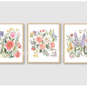 May include: Three framed watercolor paintings of floral bouquets. Each painting features a different arrangement of pink, white, purple, and yellow flowers.