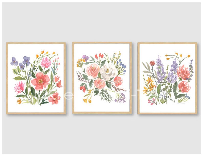 May include: Three framed watercolor paintings of floral bouquets. Each painting features a different arrangement of pink, white, purple, and yellow flowers.